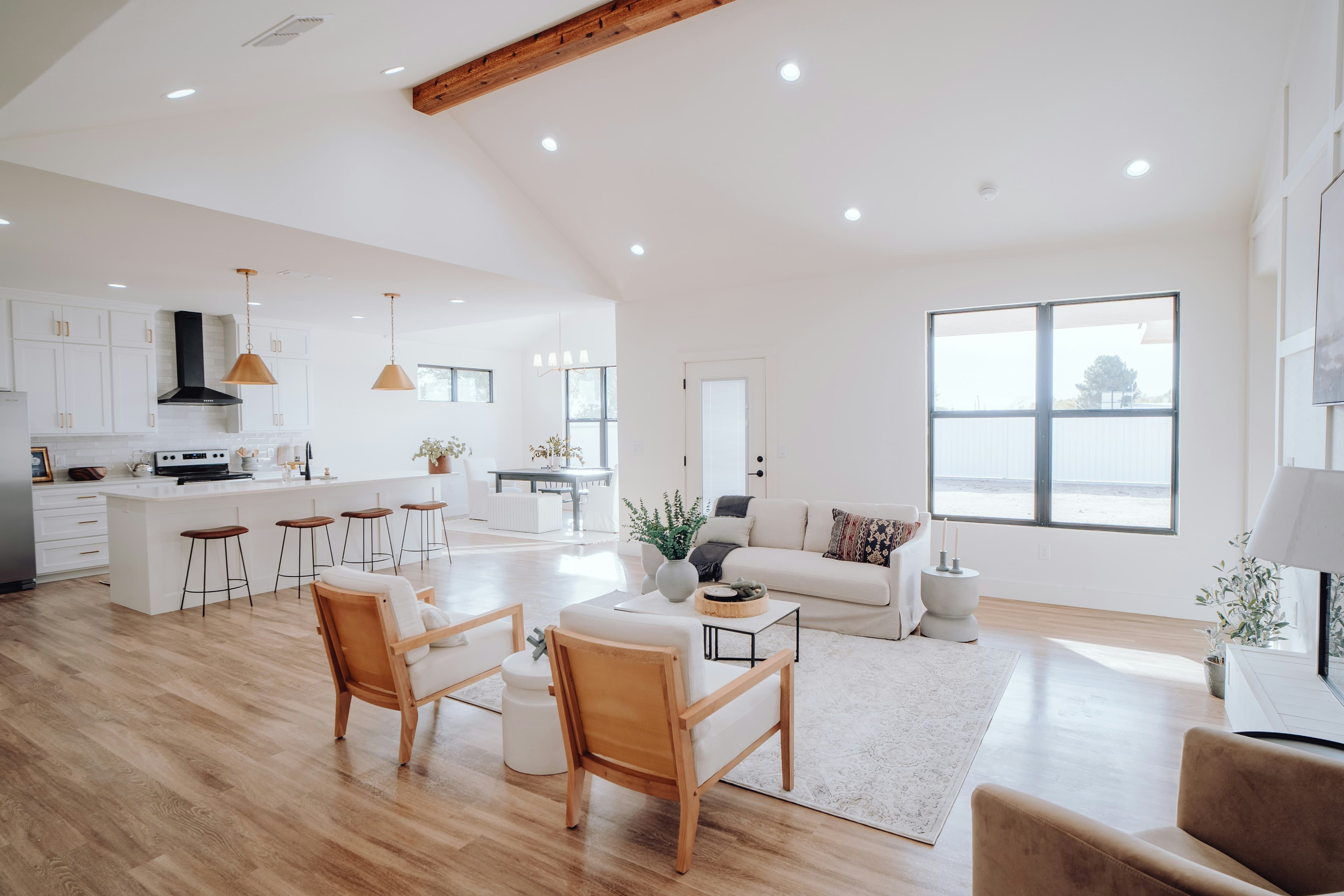 A bright, clean modern living room with a kitchen in the background representing our work quality